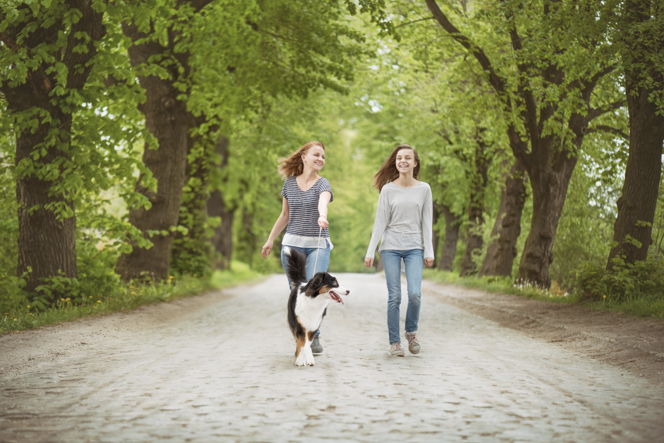 Mom and daughter walking their emotional support dog on a path