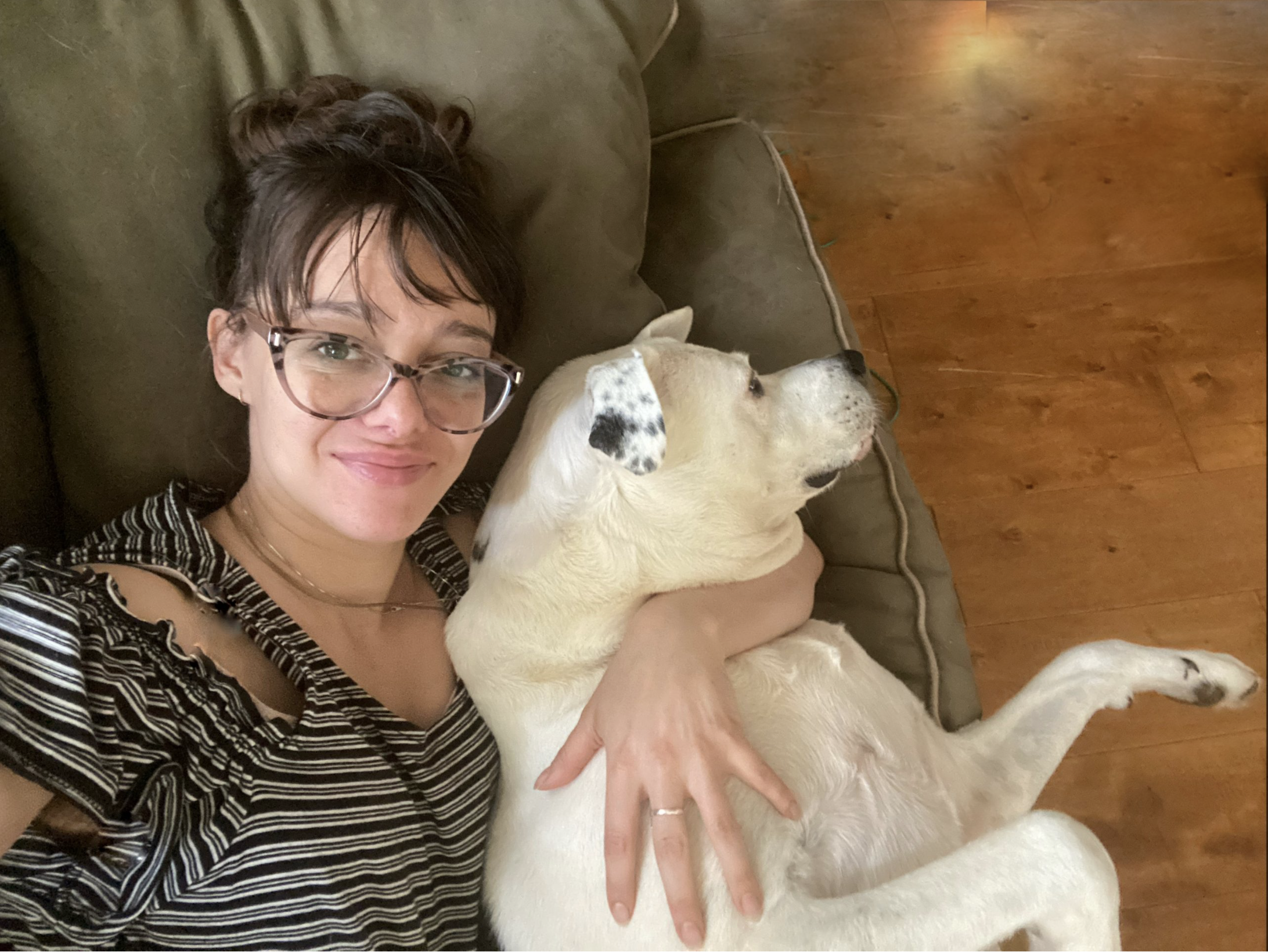 Woman sitting on a couch with her emotional support dog